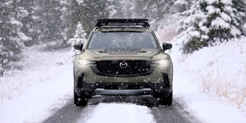 2025 Mazda CX-50 driving on a snowy mountain road